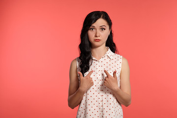 Studio shot of a beautiful girl teenager posing over a pink background.