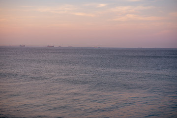 Landscape shot of ocean with boats in the horizon