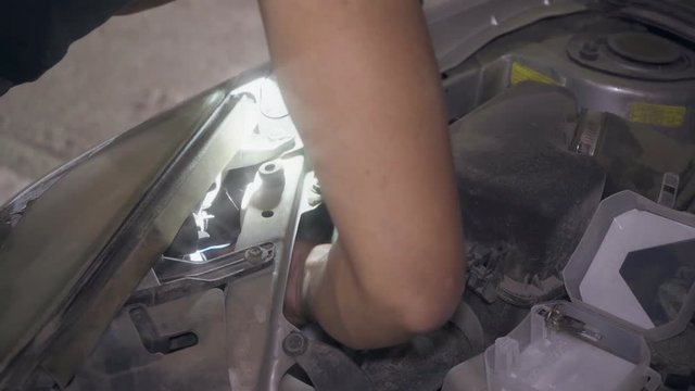 An electrician inspects the wiring in the car