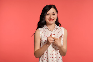 Studio shot of a beautiful girl teenager posing over a pink background.