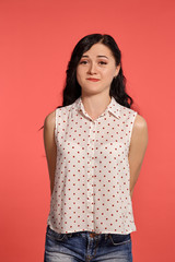 Studio shot of a beautiful girl teenager posing over a pink background.