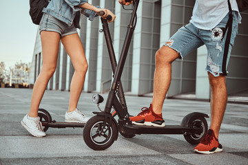 Young couple are making interesting composition from their scooters while posing for photographer.