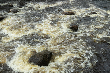 Rough river Jokelanjoki and stones in water, Kouvola, Finland.
