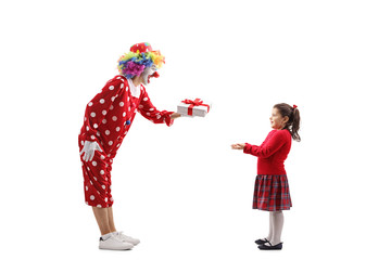Clown handing a present to a little girl