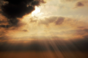 Dramatic cloudscape of orange colored sunset sky with shining sun