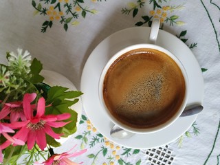 A closeup coffee cup on the table at noon.