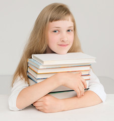 Cute girl with a stack of books;