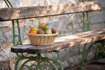 Fototapeta na wymiar Corbeille de fruits posée sur un banc ancien