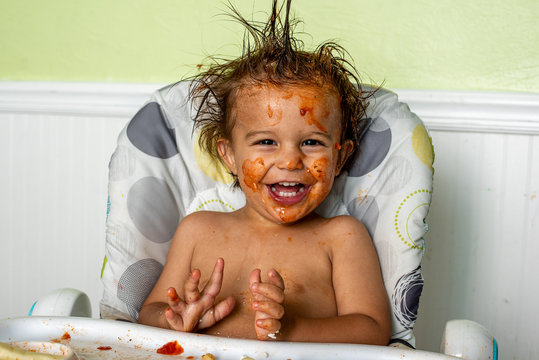 A little boy making a mess while eating