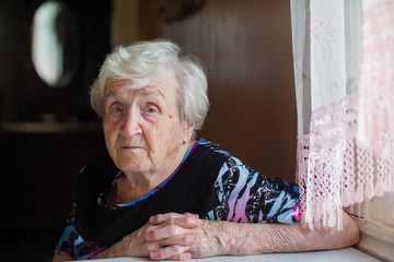Portrait of an elderly woman of slavic appearance in her house.