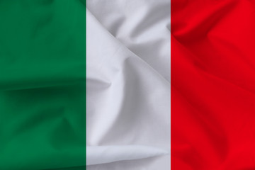 beautiful national flag of Italy on soft silk with soft folds in the wind, close-up, copy space