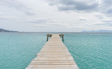 Wooden pier, calm turquoise waters in the Mediterranean Sea, holiday scenes with a sense of calm