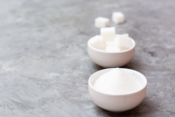 Concept advantages of granulated sugar over refined sugar. Two types of sugar in white bowls on the table, standing next to each other