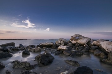 Fototapeta na wymiar Beautiful coastal seascape with rocks in the foreground at sunset