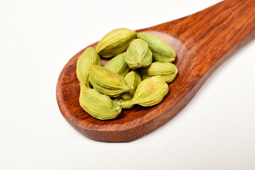 Closeup Of Cardamom In Wooden Spoon Isolated On White Background With Clipping Path