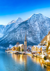 Classic postcard view of famous Hallstatt lakeside town in the Alps with traditional passenger ship...