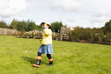 Fototapeta premium toddler girl playing exploration in spring park