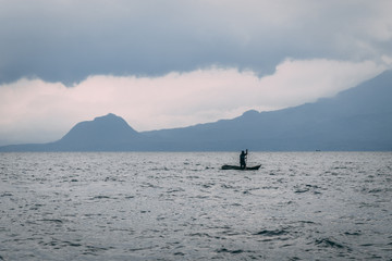 Obraz premium man on kayak on lake in front of mountain