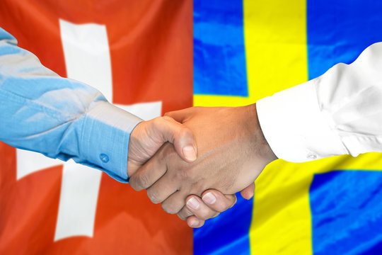 Business handshake on the background of two flags. Men handshake on the background of the Switzerland and Sweden flag. Support concept
