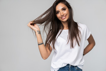 Pretty smiling joyfully female with fair hair, dressed casually, looking with satisfaction at camera, being happy. Studio shot of good-looking beautiful woman isolated against blank studio wall.