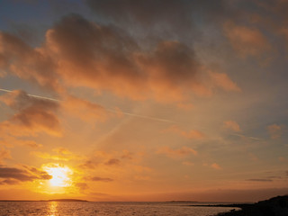 Sunset sky over ocean. Galway bay, Hare island, Dramatic cloudy sky. Warm colors.