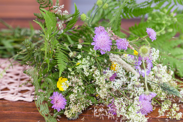 Fototapeta na wymiar A bouquet of summer wild herbs and flowers in nature, the summer solstice. Summer sun celebration