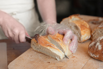 Woman cuts bread on wooden background