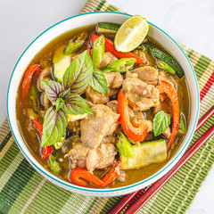 Thai Green Chicken Curry in a Bowl with Chopsticks, Garnished with Thai Basil Leaves and Lemon. Asian and Thai Food,   Oriental Cuisine Photography.