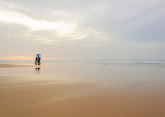 Fototapeta na wymiar passear e surfar em praia vazia ao por do sol