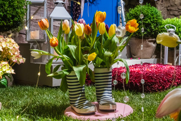 garden composition with striped rubber boots and flowers