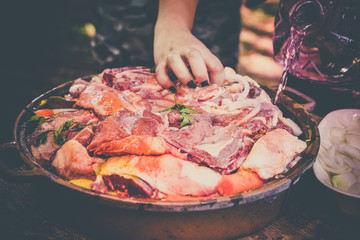 The woman's hand prepares fresh meat for baking