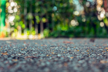 Abstract background of cement construction on green scenery – Close-up of asphalt rough surface with detailed texture on a sunny day – Sidewalk or walkway in the park