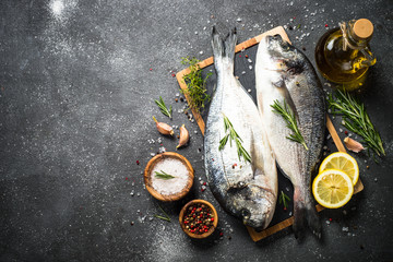 Raw dorado fish on black background.