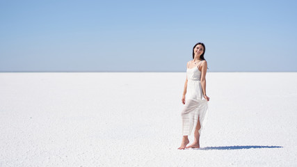 Laughing girl in a white dress, salt lake Elton in the Volgograd region in Russia.