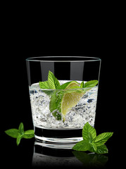 Vodka lime mojito or gin tonic  with ice in rocks glass on black background