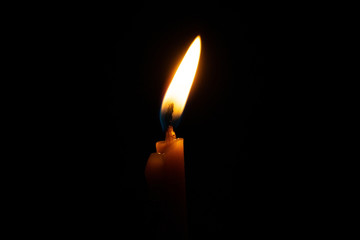 burning candle on black background