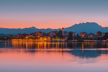Sesto Calende on Ticino River next to Lake Maggiore after the sunset with city reflectionss