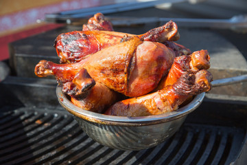 Naklejka premium Turkey legs baked on coals in a metal bowl on the grill. Food and drink.