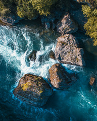 Aerial shot of a river with big rocks and rapids