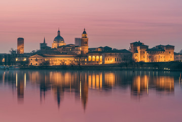 Fototapeta na wymiar UNESCO World Heritage site Mantua city with pink sky at sunset with city reflections on the Mincio River