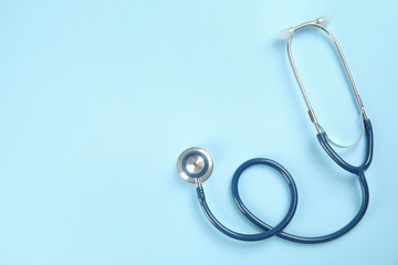 Stethoscope with space for text on color background, top view. Medical tool