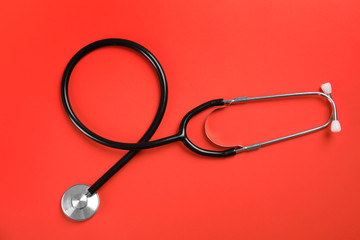 Stethoscope on color background, top view. Medical tool