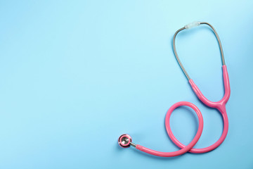 Stethoscope with space for text on color background, top view. Medical tool