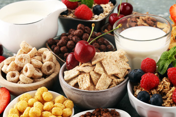 Cereal. Bowls of various cereals, berries and milk for breakfast. Muesli with kids cereals.