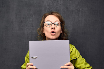 Portrait of girl, making silly face, looking out from folder