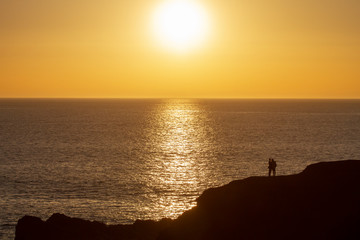 Silhouette, zwei Touristen beobachten den Sonnenuntergang