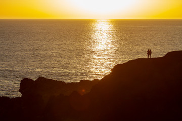 Silhouette, zwei Touristen beobachten den Sonnenuntergang