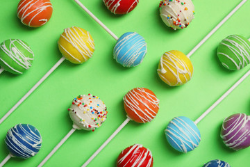 Bright delicious cake pops on color background, flat lay