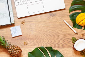 Summer Business or vacation concept flat lay with tropical leaves on the vintage wooden background....