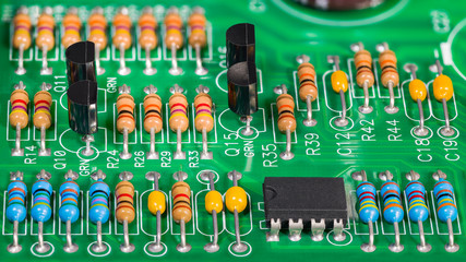 Colored electronic components. Resistors, transistors, capacitors and integrated circuit on PCB....